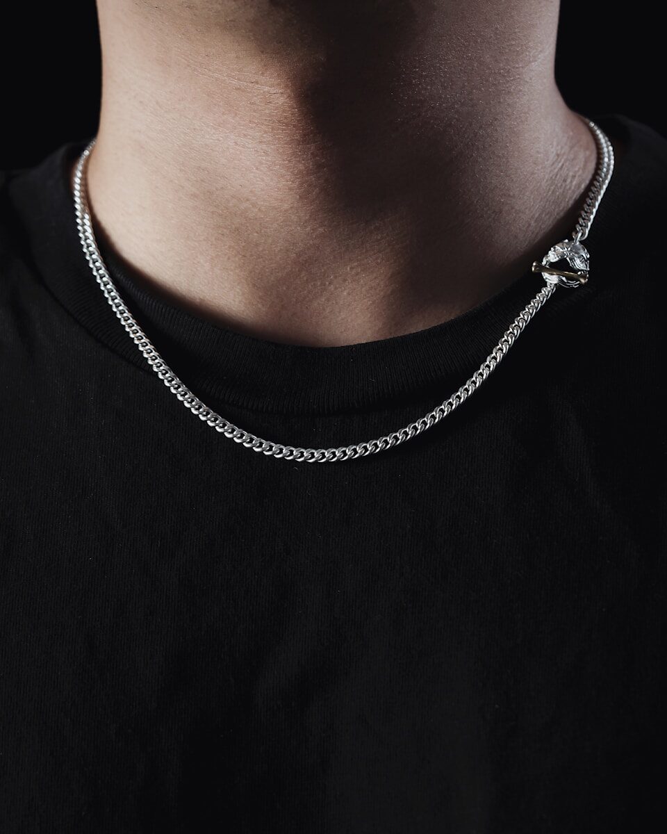 a man wearing a black shirt and a silver chain necklace